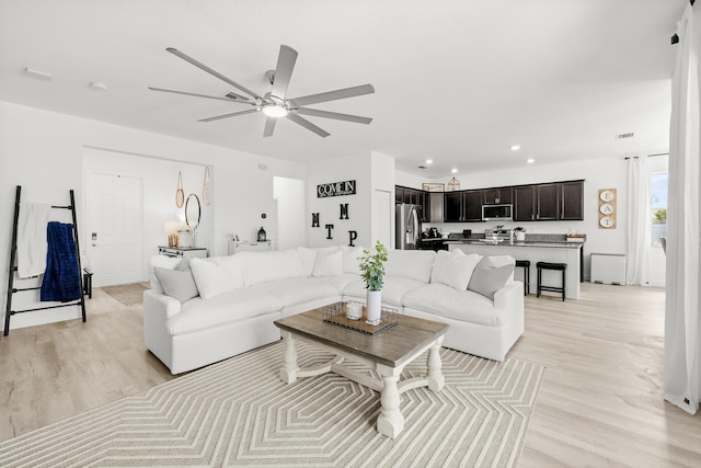 living room with recessed lighting, light wood finished floors, and ceiling fan