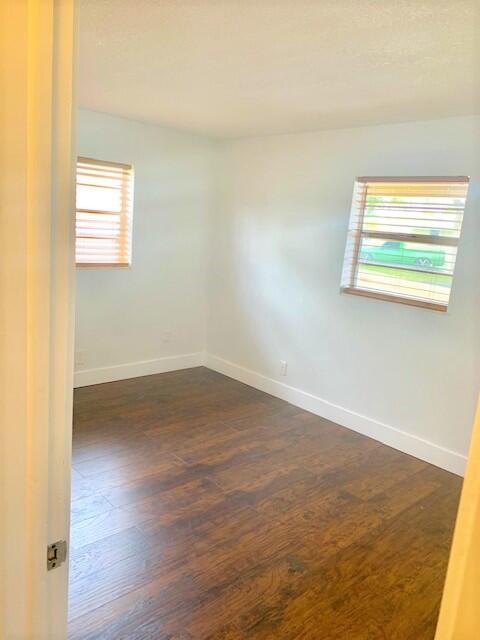 2821 Duke Ln, Delray Beach, FL 33445 - spare room with baseboards, dark wood finished floors, and a wealth of natural light