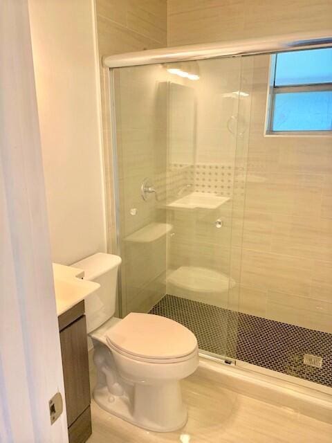 2821 Duke Ln, Delray Beach, FL 33445 - full bathroom featuring vanity, a stall shower, and toilet