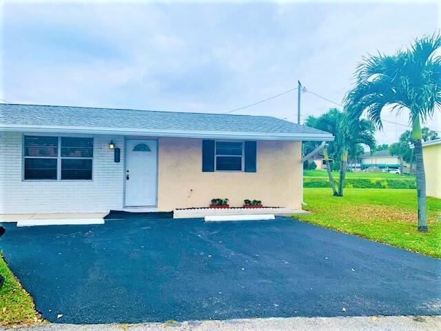 2821 Duke Ln, Delray Beach, FL 33445 - ranch-style home with uncovered parking and a front lawn