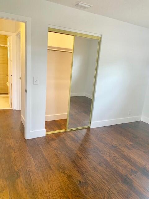 2821 Duke Ln, Delray Beach, FL 33445 - unfurnished bedroom with baseboards, wood finished floors, visible vents, and a closet