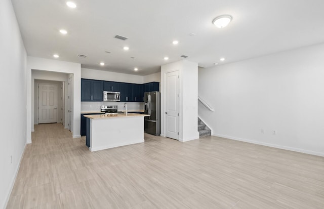 7646 SW Lucy Ln Unit 52-10, Stuart, FL 34997 - kitchen with stainless steel appliances, open floor plan, light countertops, baseboards, and an island with sink