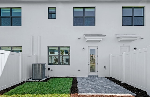 7646 SW Lucy Ln Unit 52-10, Stuart, FL 34997 - rear view of property with central AC, stucco siding, and a patio
