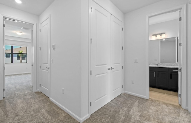 7636 SW Lucy Ln Unit Latitude 48-09, Stuart, FL 34997 - hallway featuring light carpet, baseboards, and a sink