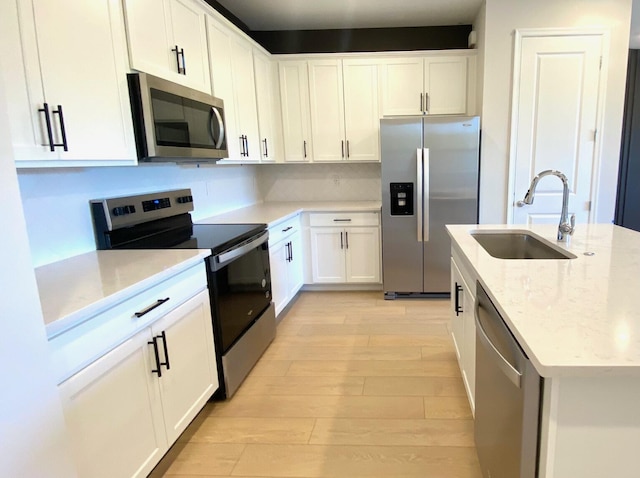 7636 SW Lucy Ln Unit Latitude 48-09, Stuart, FL 34997 - kitchen featuring appliances with stainless steel finishes, a sink, light wood-style floors, and white cabinets