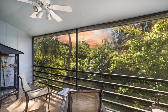 unfurnished sunroom with ceiling fan