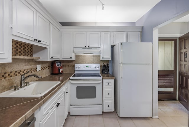 kitchen with white appliances, white cabinets, under cabinet range hood, and a sink