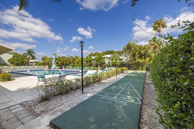 surrounding community featuring fence, a swimming pool, and shuffleboard