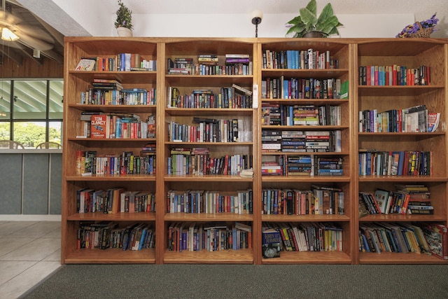 sitting room with tile patterned floors and bookshelves