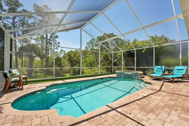 view of pool with a patio area, a pool with connected hot tub, and glass enclosure
