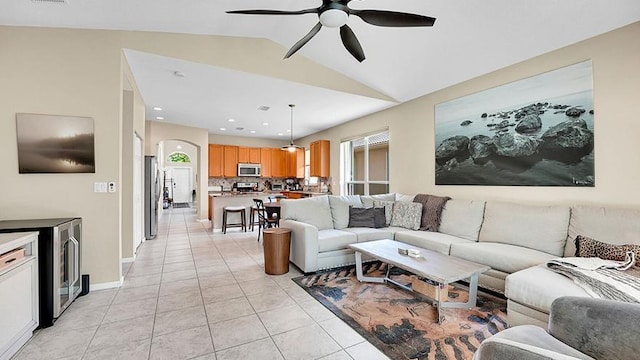 living room featuring beverage cooler, a ceiling fan, light tile patterned floors, and vaulted ceiling