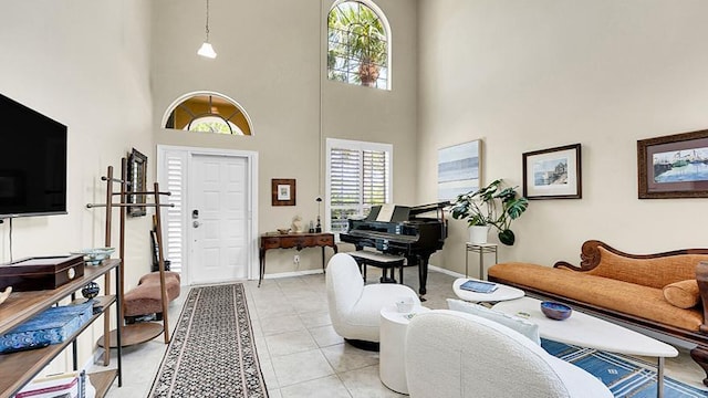living area featuring a high ceiling, baseboards, and light tile patterned flooring