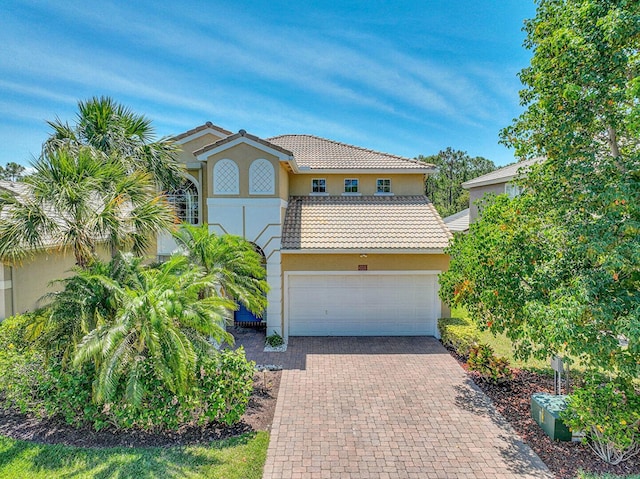 view of front of home with stucco siding, decorative driveway, and a tiled roof