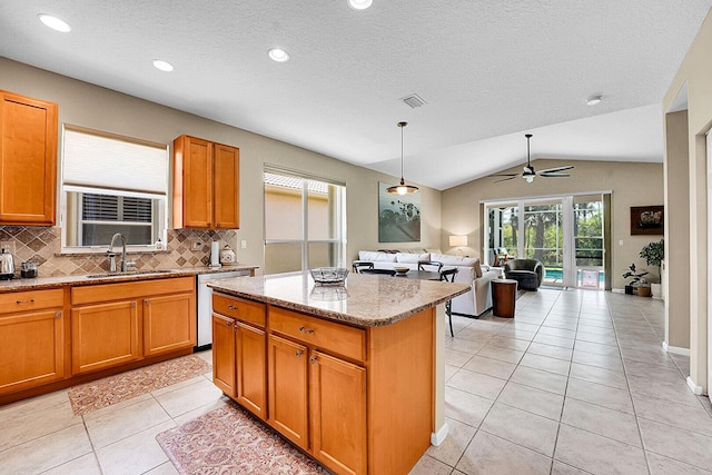 kitchen with a sink, open floor plan, backsplash, vaulted ceiling, and a kitchen island