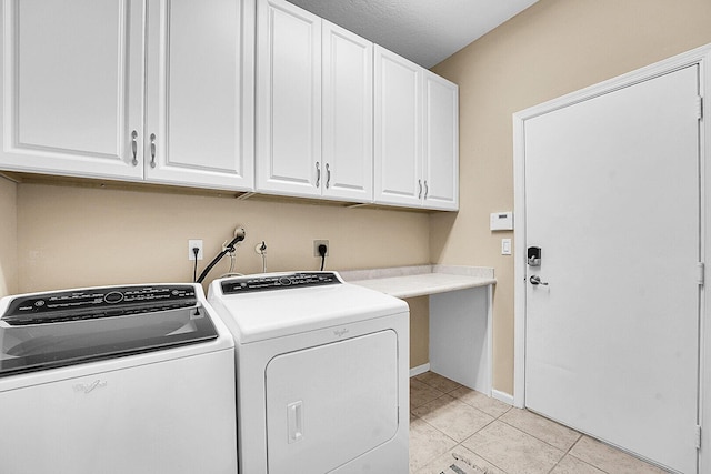 laundry area with washer and clothes dryer, cabinet space, light tile patterned flooring, and baseboards