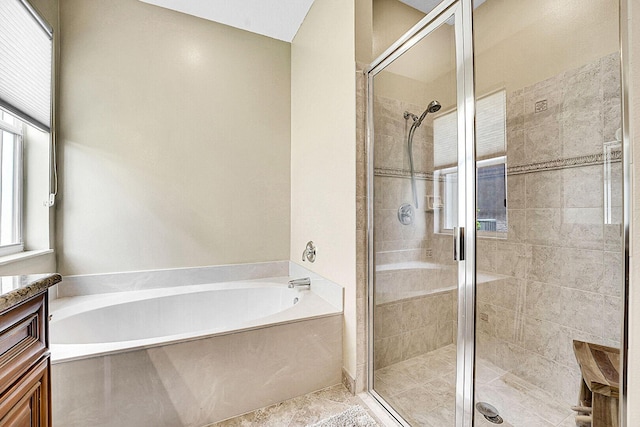 bathroom with a stall shower, a bath, and vanity