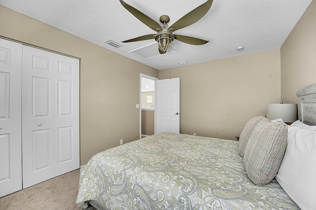 carpeted bedroom featuring a closet, ceiling fan, and a textured ceiling