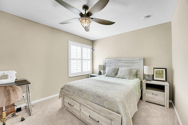 bedroom featuring light carpet, baseboards, a textured ceiling, and ceiling fan