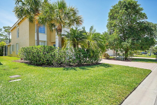 view of home's exterior featuring stucco siding, a lawn, and driveway