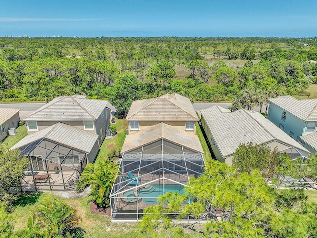 aerial view of property and surrounding area with a heavily wooded area