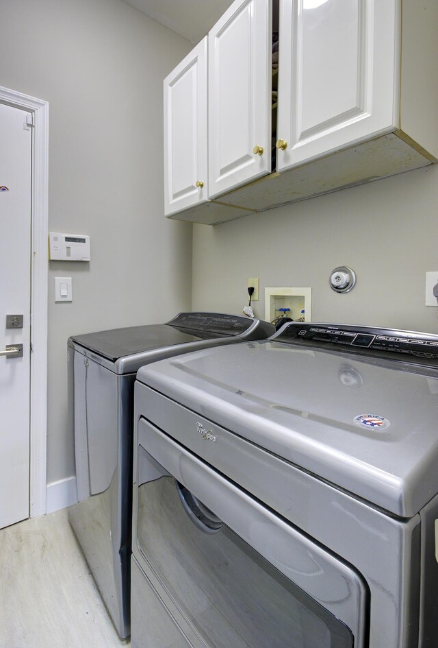 7861 Manor Forest Ln, Boynton Beach, FL 33436 - washroom featuring cabinet space, washer and clothes dryer, light wood-style flooring, and baseboards