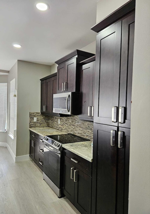 7861 Manor Forest Ln, Boynton Beach, FL 33436 - kitchen featuring electric stove, stainless steel microwave, tasteful backsplash, light wood-style flooring, and baseboards