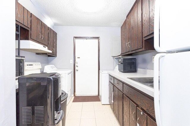 1043 NE 20th St, Belle Glade, FL 33430 - clothes washing area featuring washing machine and clothes dryer, laundry area, a sink, a textured ceiling, and light tile patterned floors