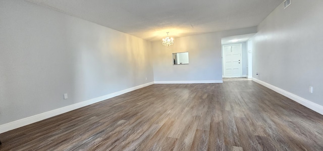 4141 NW 44th Ave Unit 217, Lauderdale Lakes, FL 33319 - unfurnished room with an inviting chandelier, baseboards, dark wood finished floors, and visible vents
