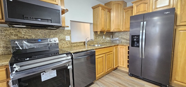 4141 NW 44th Ave Unit 217, Lauderdale Lakes, FL 33319 - kitchen with light stone countertops, a sink, light wood finished floors, stainless steel appliances, and decorative backsplash