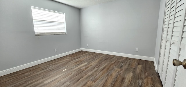 4141 NW 44th Ave Unit 217, Lauderdale Lakes, FL 33319 - unfurnished room featuring baseboards, dark wood finished floors, and a textured ceiling