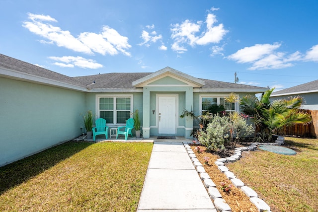 1566 SW Andalusia Rd, Port Saint Lucie, FL 34953 - view of front facade featuring a shingled roof, a front lawn, and stucco siding