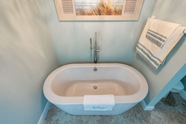 1566 SW Andalusia Rd, Port Saint Lucie, FL 34953 - full bath featuring a freestanding tub, baseboards, and tile patterned flooring