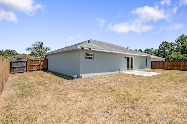 1566 SW Andalusia Rd, Port Saint Lucie, FL 34953 - back of house with stucco siding, a fenced backyard, a gate, a patio area, and a yard