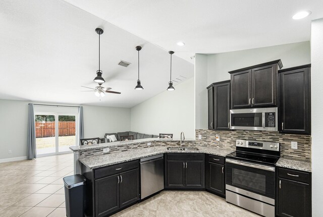 1566 SW Andalusia Rd, Port Saint Lucie, FL 34953 - kitchen with a sink, a peninsula, open floor plan, a ceiling fan, and stainless steel appliances