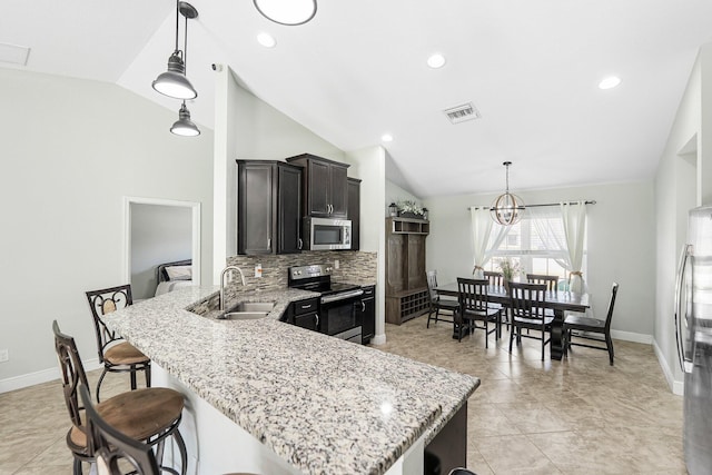 1566 SW Andalusia Rd, Port Saint Lucie, FL 34953 - kitchen featuring lofted ceiling, baseboards, a sink, backsplash, and stainless steel appliances