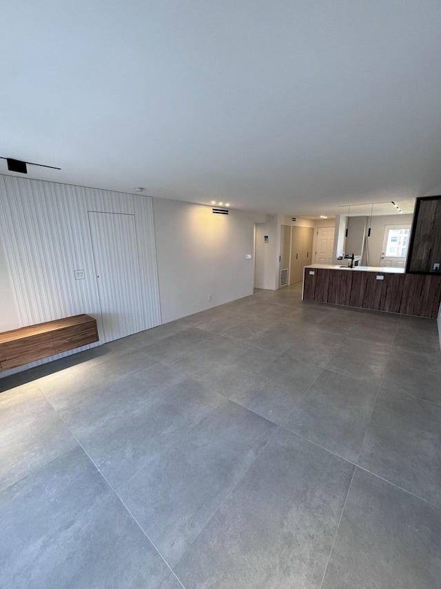 unfurnished living room with visible vents and concrete flooring
