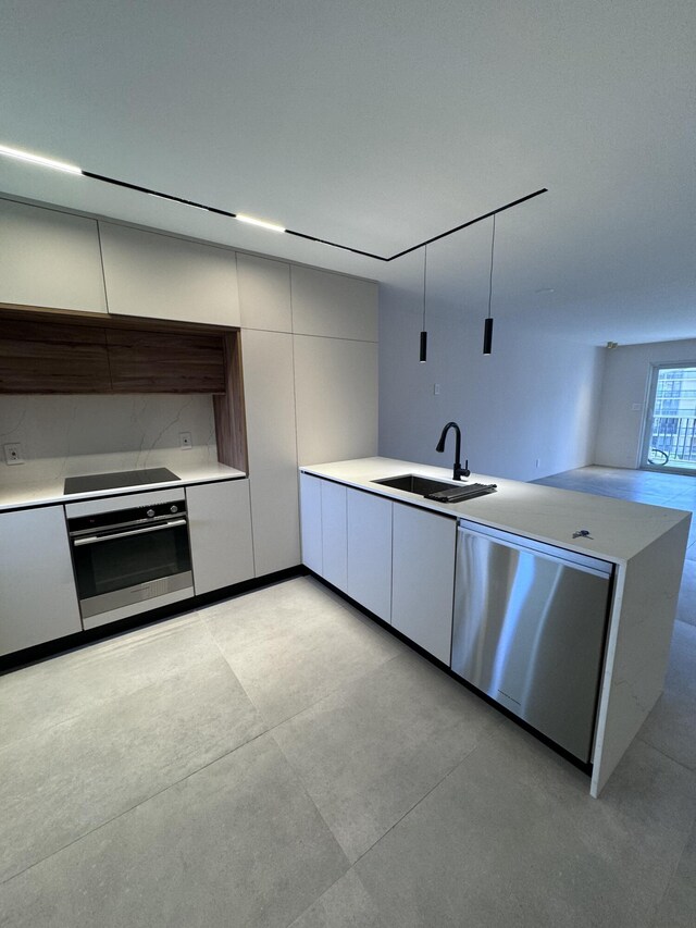 kitchen featuring a sink, appliances with stainless steel finishes, modern cabinets, and light countertops