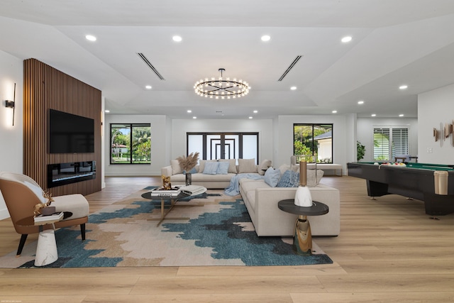 living room with light wood-style floors, billiards, healthy amount of natural light, recessed lighting, and a glass covered fireplace