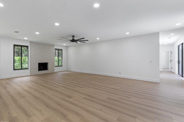 unfurnished living room with light wood-style flooring, baseboards, recessed lighting, ceiling fan, and a fireplace