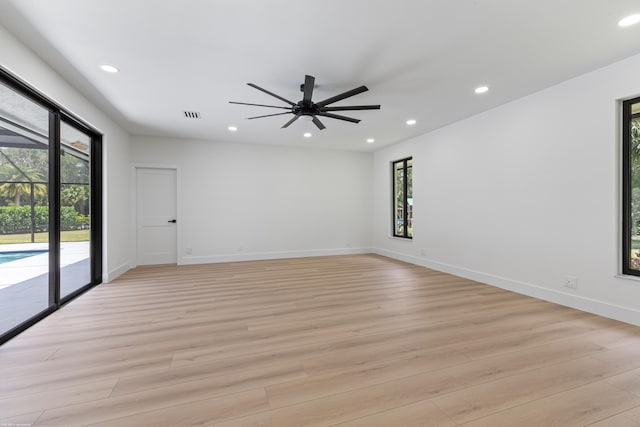 spare room with recessed lighting, light wood-style floors, a ceiling fan, and baseboards