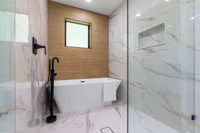 full bathroom featuring tile walls, a freestanding tub, marble tiled floors, a marble finish shower, and recessed lighting