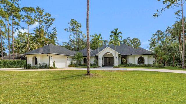 ranch-style house with stucco siding, driveway, a front lawn, and an attached garage