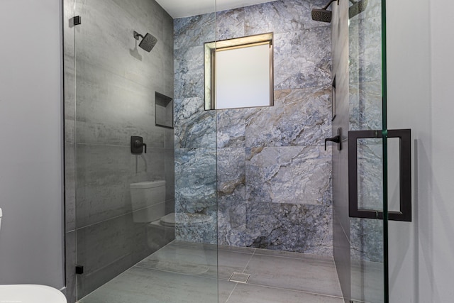 bathroom featuring toilet and a stall shower
