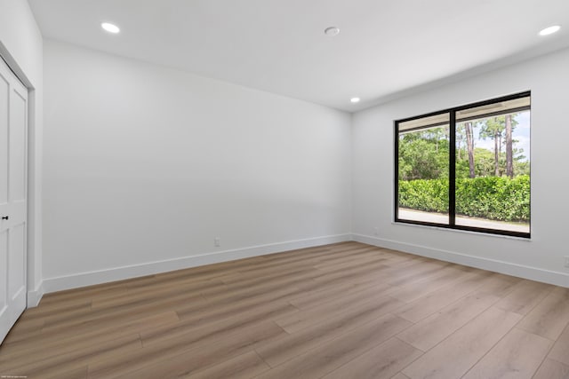 unfurnished bedroom featuring light wood finished floors, recessed lighting, baseboards, and a closet