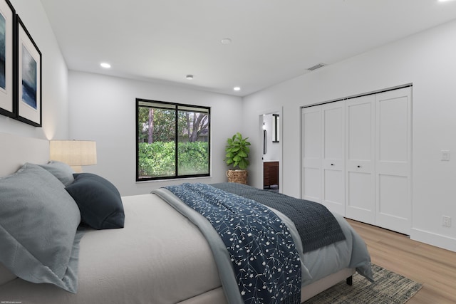 bedroom featuring wood finished floors, recessed lighting, a closet, and baseboards