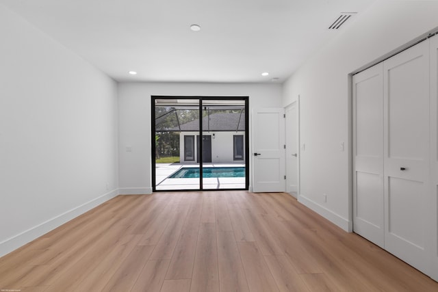 spare room featuring light wood-type flooring, baseboards, recessed lighting, and a sunroom
