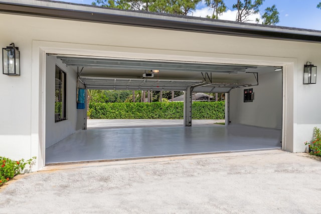 garage with a garage door opener, concrete driveway, and electric panel