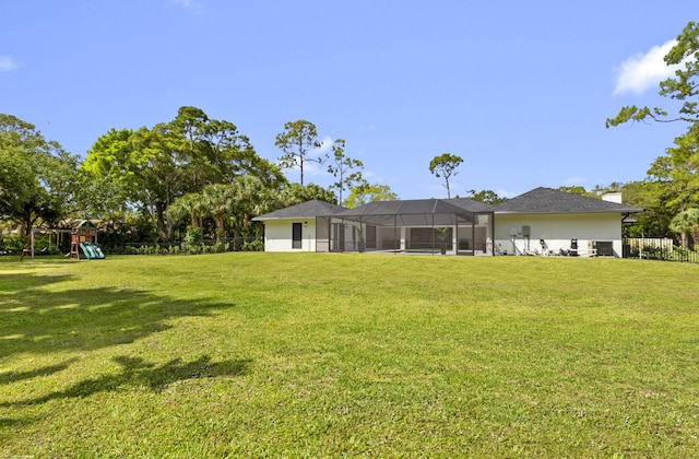view of yard with a playground and glass enclosure