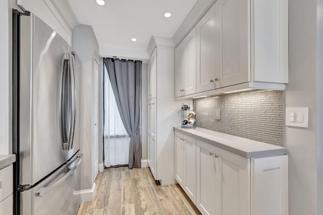 kitchen featuring freestanding refrigerator, light countertops, tasteful backsplash, white cabinetry, and recessed lighting