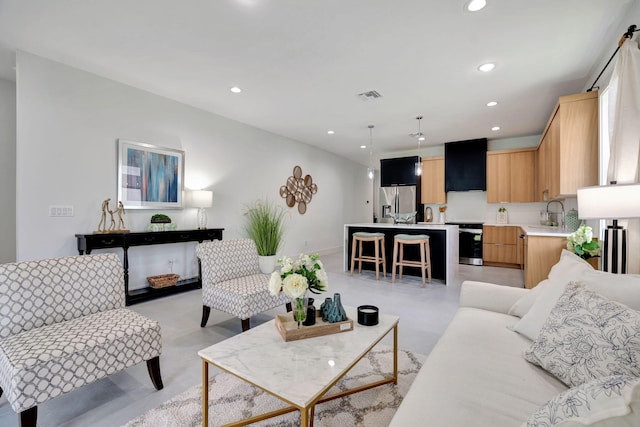 living area featuring finished concrete flooring, recessed lighting, and visible vents